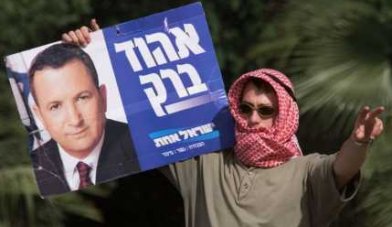 Сторонник Ликуда, переодевшись в палестинца, пугает сограждан предвыборным плакатом Барака.
Фото: Жером Дилэй, Associated Press